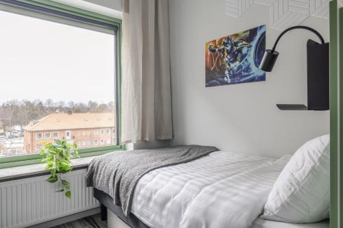 um quarto com uma cama e uma grande janela em HomeX Hotel for Gamers em Täby