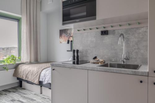 uma cozinha com um lavatório e uma cama em HomeX Hotel for Gamers em Täby