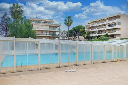 a building with a swimming pool in front of a building at Residence De Vacance, superb 3 room apartment with in Saint-Laurent-du-Var