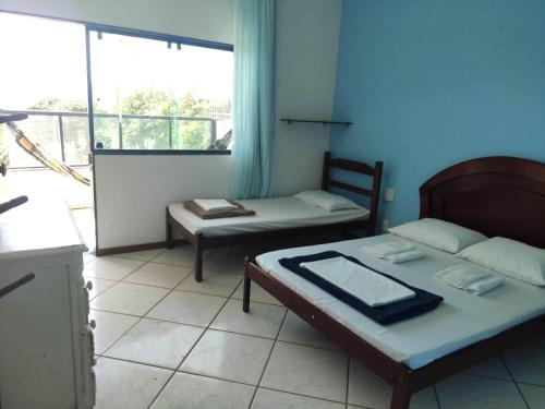 a room with two beds and a large window at Casa Vista do Mar, praia e piscina in Vila Velha
