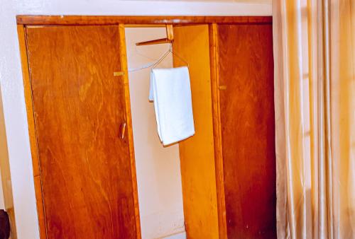 a wooden door with a white towel hanging on it at MOUCECORE in Kigali