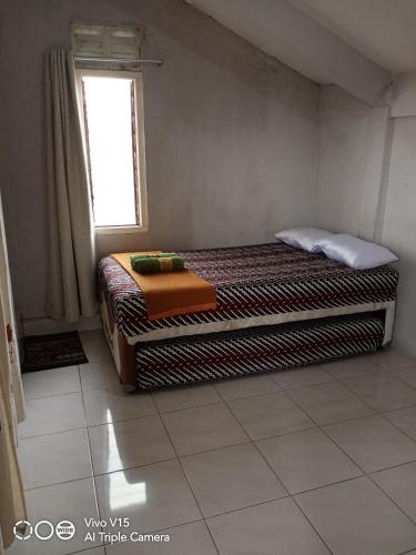 Una cama o camas en una habitación de Losmen Fadel Malioboro Jogja