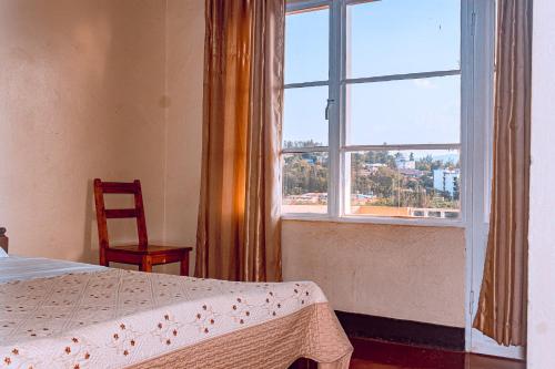 1 dormitorio con cama y ventana grande en MOUCECORE en Kigali