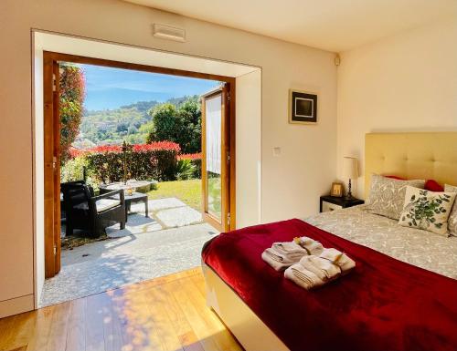 - une chambre avec un lit et une grande porte coulissante en verre dans l'établissement Casa do Pomar - Eido do Pomar, à Arcos de Valdevez