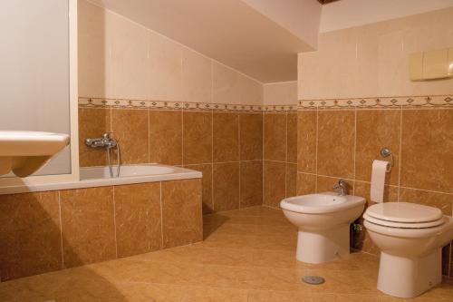 a bathroom with a toilet and a tub and a sink at Ruggiero Park Hotel in Vallo della Lucania