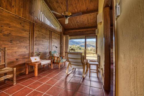 ein Wohnzimmer mit Holzwänden und einem großen Fenster in der Unterkunft La Hospedería Del Silencio in Robledillo de la Vera