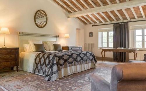 een slaapkamer met een bed, een tafel en een spiegel bij Villa Pieve in Palaia