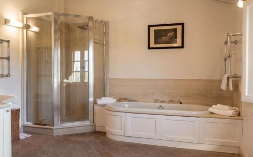 a white bathroom with a shower and a tub at Villa Pieve in Palaia
