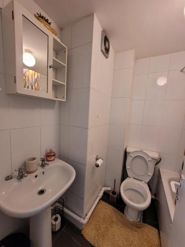 a white bathroom with a sink and a toilet at Tastefully decorated 1 bed flat near AbbeyWood in Belvedere
