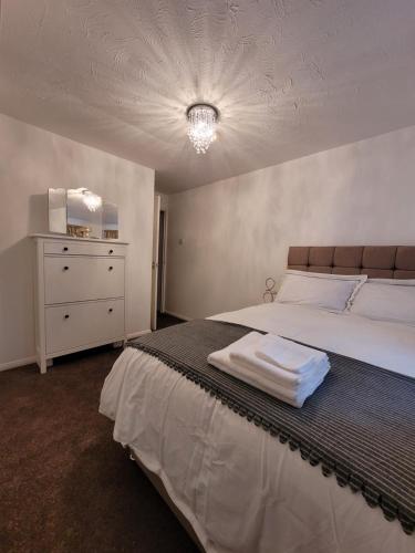 a bedroom with a large bed with a dresser and a bedsenalsenalsenal at Tastefully decorated 1 bed flat near AbbeyWood in Belvedere