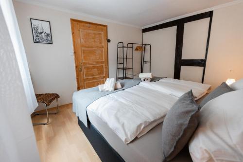 - une chambre avec un grand lit blanc et une porte en bois dans l'établissement Charmantes Fachwerkhaus in Ediger-Eller - Nähe Calmont Kletterstieg mit 2 Schlafzimmer, Netflix, à Ediger-Eller