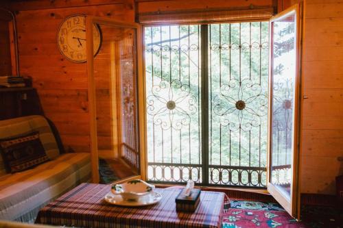 Zimmer mit einem großen Fenster und einer Uhr an der Wand in der Unterkunft Treehouse Bosnia in Trnovo