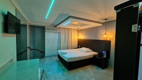 um quarto com uma cama num quarto com luzes azuis em Gran Motel em Taguatinga