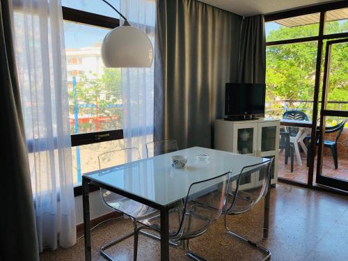 una sala da pranzo con tavolo, sedie e TV di Apartamentos la Nogalera a Torremolinos