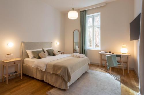 a bedroom with a bed and a desk and a window at Design Apartments near Botanical Garden in Zagreb