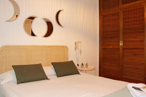 - une chambre avec un lit et deux miroirs sur le mur dans l'établissement Apartamento Calle Feria, à Séville