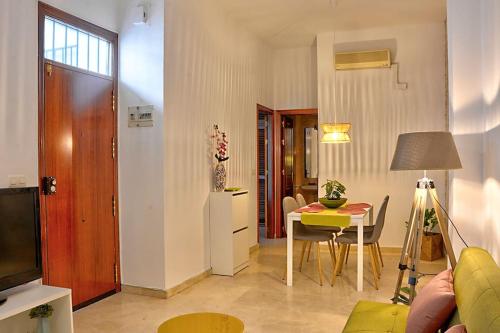 - un salon avec une table et une salle à manger dans l'établissement Apartamento Calle Feria, à Séville