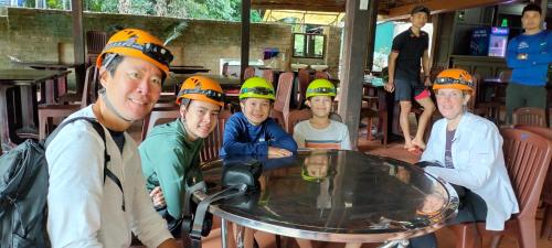 a group of people wearing hard hats at a table at Carambola Bungalow in Phong Nha