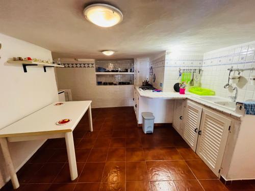 a kitchen with white counters and a brown floor at Lunatica Immobilevante in Ponza
