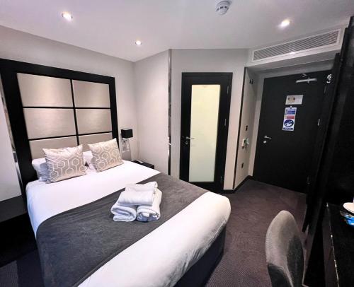 Una habitación de hotel con una cama con toallas. en Great St Helen Hotel en Londres