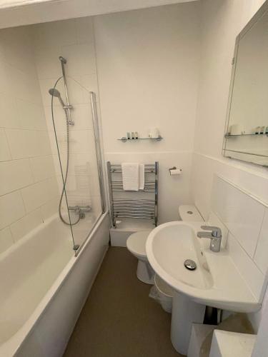 a bathroom with a sink and a toilet and a shower at The Bell Inn in Oxford