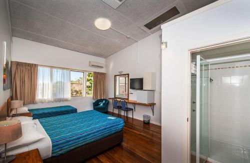 a hotel room with a bed and a sliding glass door at Diggers Tavern in Bellingen