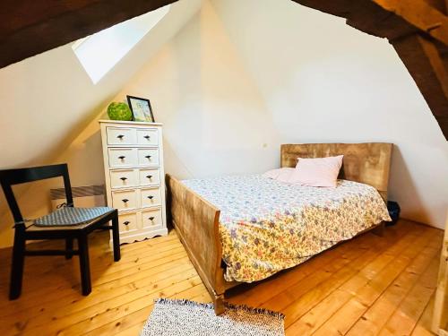 une chambre avec un lit, une commode et une chaise dans l'établissement Jolie Bergerie rénovée à 5 min de Laon, à Mons-en-Laonnois