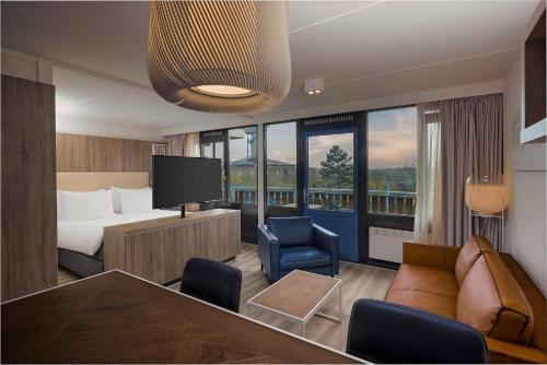 ネスにあるFletcher Hotel-Restaurant Noordsee-Amelandのベッドとテレビが備わるホテルルームです。