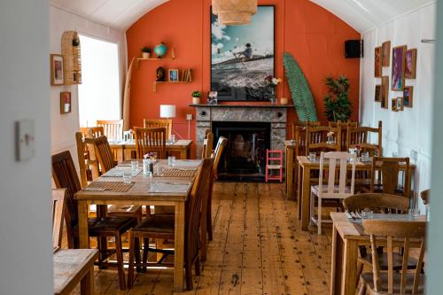 ein Restaurant mit Holztischen und -stühlen und einem Kamin in der Unterkunft Pure Magic Lodge in Slievemore