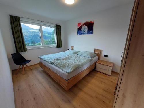 a bedroom with a bed and a window at Ferienwohnung Pölvenblick in Söll