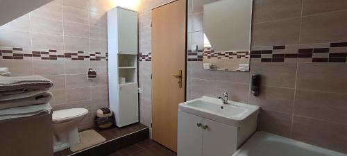 a small bathroom with a sink and a toilet at Penzión Veperec in Hokovce