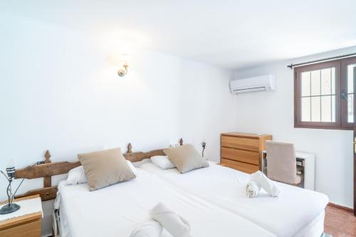 2 camas blancas en una habitación con ventana en Los Naranjos 25A Private Pool Capistrano Village, en Nerja