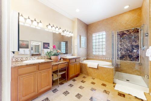La salle de bains est pourvue d'une baignoire, d'un lavabo et d'une douche. dans l'établissement Life by the Palms Permit# 50342, à Indio
