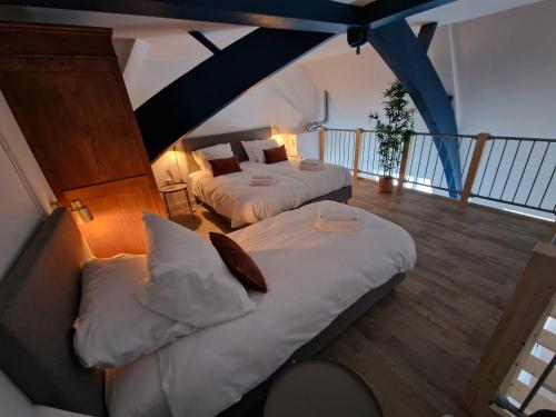 two beds in a room with a balcony at Woonhotel Petruskerk in Vlissingen