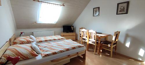 Schlafzimmer mit einem Bett und einem Esstisch in der Unterkunft Penzión Veperec in Hokovce