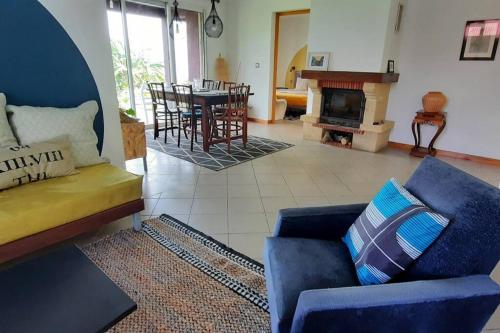 a living room with a blue couch and a fireplace at Le Tibouchina , gîte chaleureux à la ferme in Le Tampon
