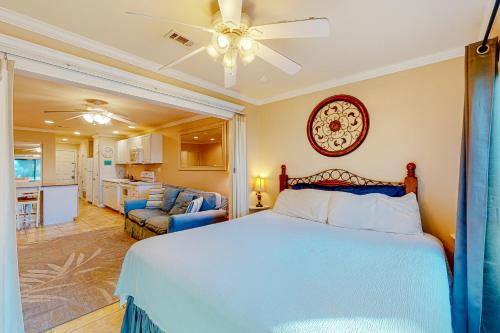 ein Schlafzimmer mit einem Bett und ein Wohnzimmer in der Unterkunft Sunset Harbor Palms 2 102 Luzviminda Cove in Navarre