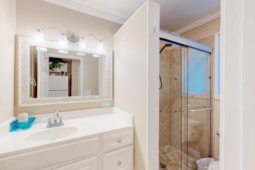La salle de bains blanche est pourvue d'un lavabo et d'une douche. dans l'établissement Sunset Harbor Palms 2 102 Luzviminda Cove, à Navarre