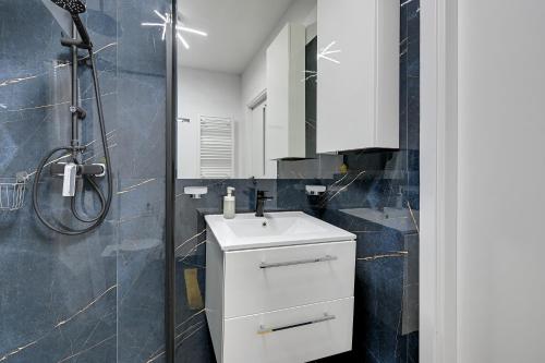 グダニスクにあるWAVE APARTMENTS-GOLD EXCLUSIVEのバスルーム(白いシンク、シャワー付)