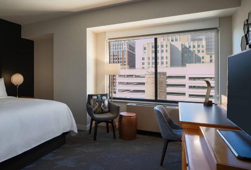 a hotel room with a bed and a large window at Renaissance Des Moines Savery Hotel in Des Moines