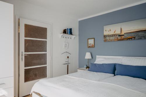 a bedroom with a white bed and blue walls at Das kleine Haus in Breitenbrunn