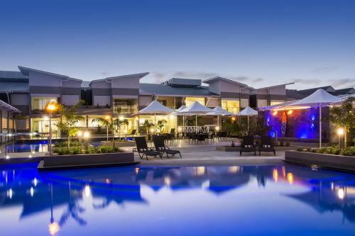 a hotel with a swimming pool at night at 1770 Lagoons Central Apartment Resort Official in Agnes Water