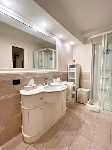 a bathroom with a sink and a mirror and a shower at Casa Fantasia in Tremezzo