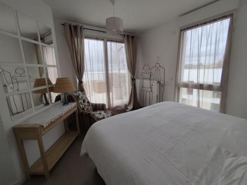 une chambre avec un lit, un bureau et une fenêtre dans l'établissement Rueil-Malmaison appartement spacieux et calme, à Rueil-Malmaison