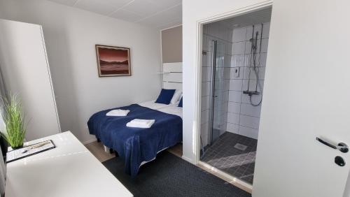 a hotel room with a bed and a shower at Hotel Vanha-Merivartioasema in Kotka