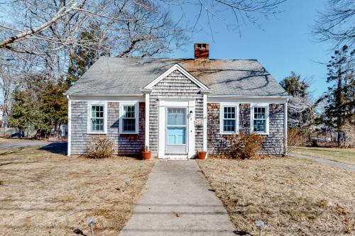 a small white house with a blue door at Sea Glass Cottage in Sandwich