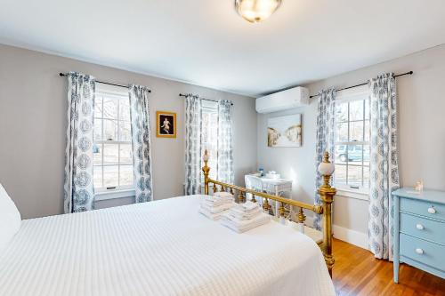 - une chambre avec un lit blanc et 2 fenêtres dans l'établissement Sea Glass Cottage, à Sandwich