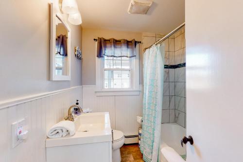 une salle de bain avec un lavabo, des toilettes et une douche dans l'établissement Sea Glass Cottage, à Sandwich