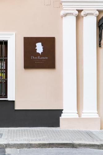 a sign on the side of a building with two columns at Hotel Casa Palacio Don Ramón in Seville