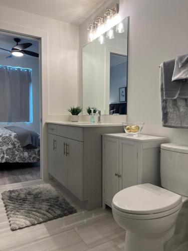 a bathroom with a toilet and a sink and a mirror at Condo Cuteness with Stellar View ~ On The Water & Perfectly Located in Sarasota